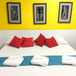 Hotel Belmar Galeria - Queen sized bed in front of gallery wall | Between Hola and Hello